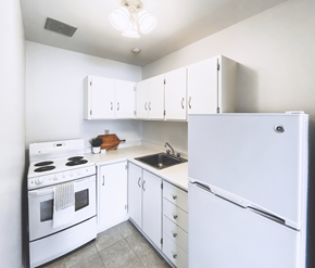 St. John's apartment for rent - A white kitchen with a refrigerator, stove, and cabinets.