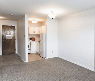 St. John's apartment for rent - A kitchen with white cabinets and a brown door.