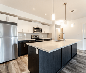 Edmonton apartment for rent - A modern kitchen with a large island and stainless steel appliances.