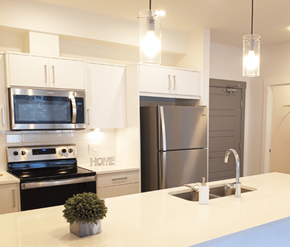 Calgary apartment for rent - A modern kitchen with a stove, microwave, and refrigerator.