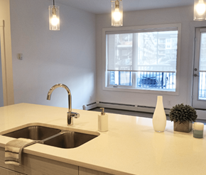 Calgary apartment for rent - A kitchen counter with a sink and a window in the background.