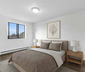 Waterloo apartment for rent - A bedroom with a large bed and a framed leaf picture on the wall.