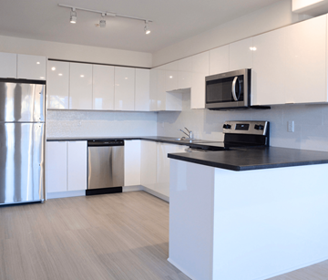 Halifax apartment for rent - A modern kitchen with white cabinets and a black countertop.