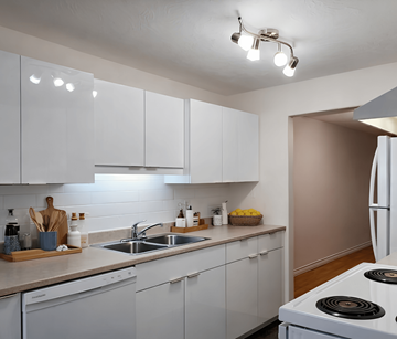 Riverview apartment for rent - A kitchen with white cabinets and a stove top oven.
