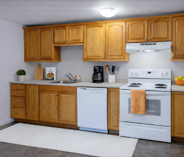 Riverview apartment for rent - A kitchen with wooden cabinets and white appliances.