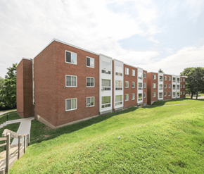 Fredericton apartment for rent - A long brick building with a white trim and windows.