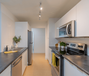 Fredericton apartment for rent - A modern kitchen with a stainless steel refrigerator, oven, and microwave.