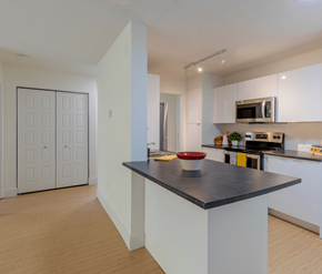 Fredericton apartment for rent - A kitchen with a black countertop and white cabinets.
