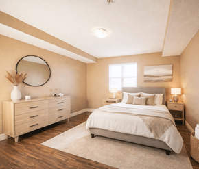 Dieppe apartment for rent - A bedroom with a large bed, a dresser, and a mirror on the wall.