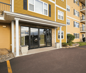 Dieppe apartment for rent - A yellow building with a glass door and a white pillar.