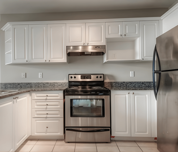 London apartment for rent - A kitchen with white cabinets and a black stove top oven.