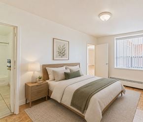Kitchener apartment for rent - A bedroom with a bed, nightstand, and lamp.
