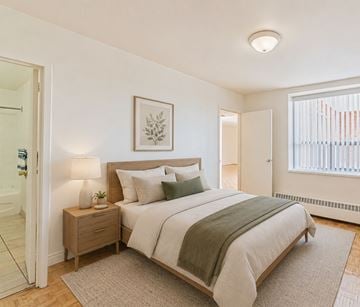 Kitchener apartment for rent - A bedroom with a bed, nightstand, and lamp.