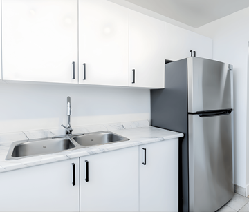 Kitchener apartment for rent - A kitchen with white cabinets and a stainless steel refrigerator.