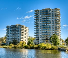 Cambridge apartment for rent - Two tall residential buildings are situated next to a body of water.