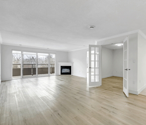 Cambridge apartment for rent - A spacious room with a fireplace and large windows.