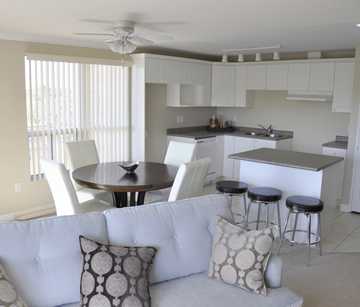 Cambridge apartment for rent - A white couch with a round table and bar stools in a kitchen.