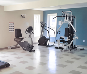 Saint John apartment for rent - A gym with a variety of equipment including treadmills, stationary bikes, and weight machines.
