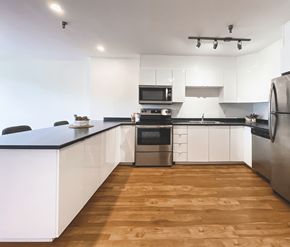 St. Johns apartment for rent - A modern kitchen with wooden floors and stainless steel appliances.