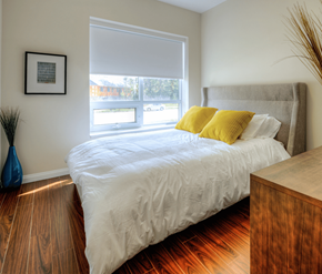 Cambridge apartment for rent - A bedroom with a bed, wooden nightstand, and a window with blinds.