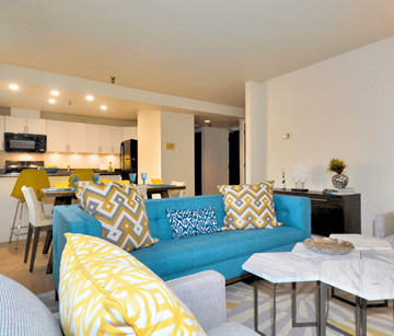 Bedford apartment for rent - A blue couch with yellow and white pillows sits in a modern living room.