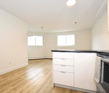 Halifax apartment for rent - A kitchen with white cabinets and a black countertop.
