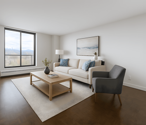 Mississauga apartment for rent - A living room with a white couch, a grey armchair, a wooden coffee table, and a large window.