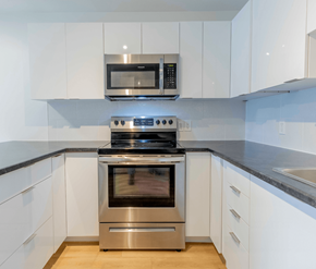 Fredericton apartment for rent - A modern kitchen with a stainless steel oven and microwave above it.