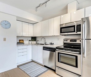 Calgary apartment for rent - A modern kitchen with stainless steel appliances and white cabinets.