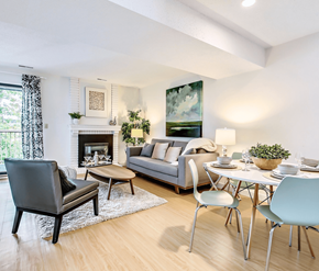 Calgary apartment for rent - A modern living room with a grey sofa, a black chair, a coffee table, and a fireplace.