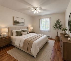 Riverview apartment for rent - A bedroom with a large bed, a ceiling fan, and a painting on the wall.