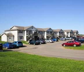 Riverview apartment for rent - A parking lot with cars and apartment buildings in the background.