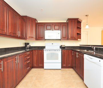 Dartmouth apartment for rent - A kitchen with brown cabinets and a white stove top oven.
