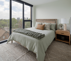 Waterloo apartment for rent - A bedroom with a large bed and a view of the city.