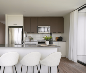 Waterloo apartment for rent - A modern kitchen with white chairs and brown cabinets.