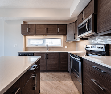 Edmonton apartment for rent - A modern kitchen with dark wood cabinets and stainless steel appliances.