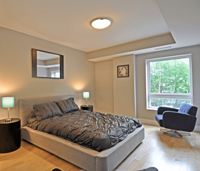 Fredericton apartment for rent - A bedroom with a large bed and a chair.