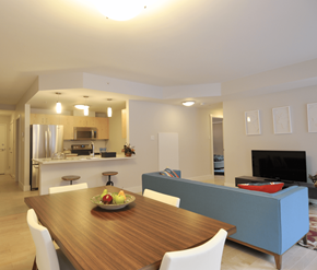 Fredericton apartment for rent - A modern dining room with a wooden table and white chairs.
