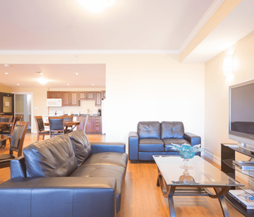Dartmouth apartment for rent - A living room with a black leather couch and a glass coffee table.