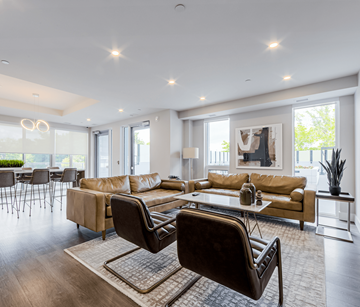Mississauga apartment for rent - A modern living room with a brown leather chair in the foreground.