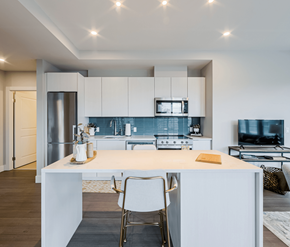 Mississauga apartment for rent - A modern kitchen with white cabinets and a central island.