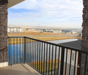 Calgary apartment for rent - A balcony with a view of a field and buildings.