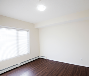 Calgary apartment for rent - A room with a window and wooden floors.
