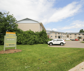 Fredericton apartment for rent - A sign in front of a building advertises that it is now renting.