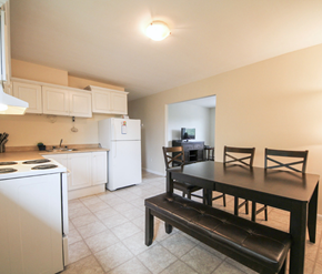 Fredericton apartment for rent - A kitchen with a white refrigerator and a black table.