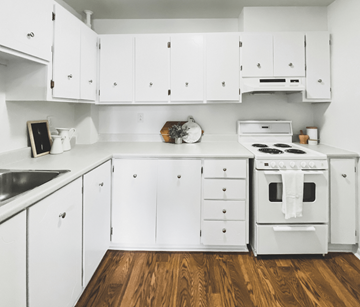 St. John's apartment for rent - A white kitchen with wooden floors and a stove top oven.
