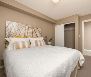 Sherwood Park apartment for rent - A bedroom with a large bed and a painting on the wall.