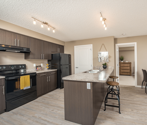 Sherwood Park apartment for rent - A kitchen with a black stove top oven and a black refrigerator.