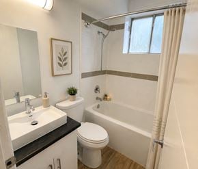 London apartment for rent - A bathroom with a white toilet, sink, and bathtub.