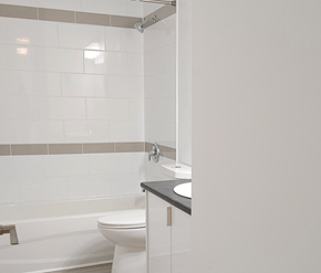 Fredericton apartment for rent - A white toilet sits next to a sink in a bathroom.